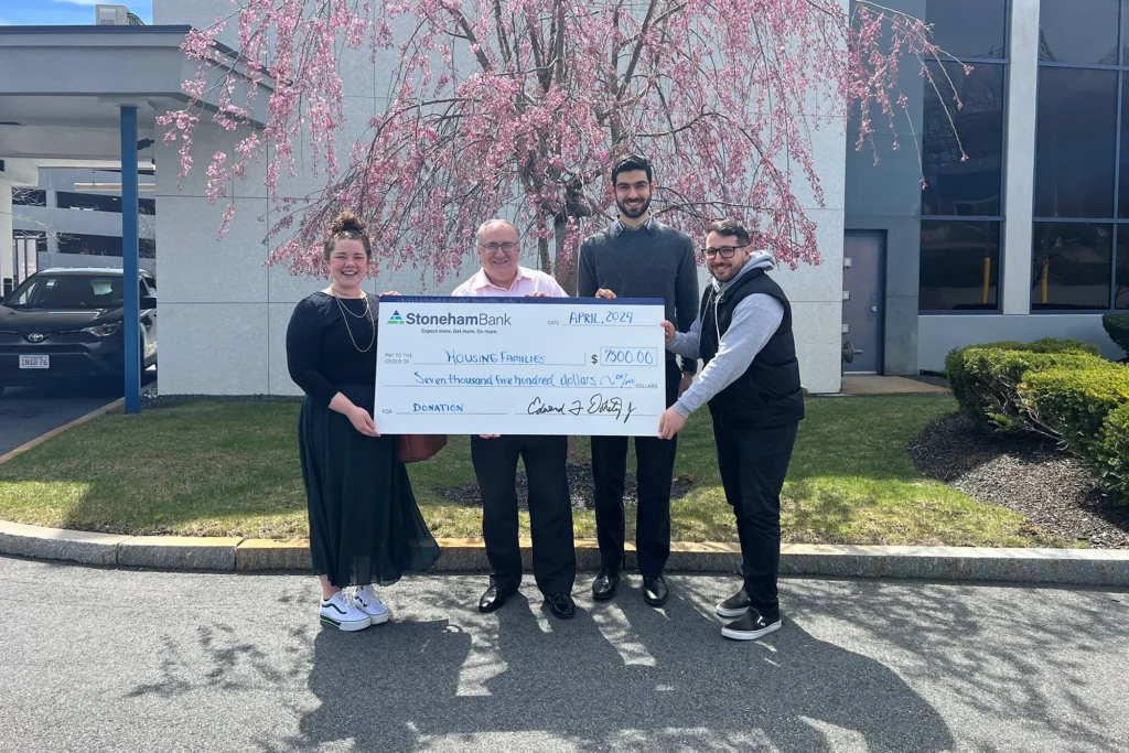 People holding a check donation from Stoneham Bank